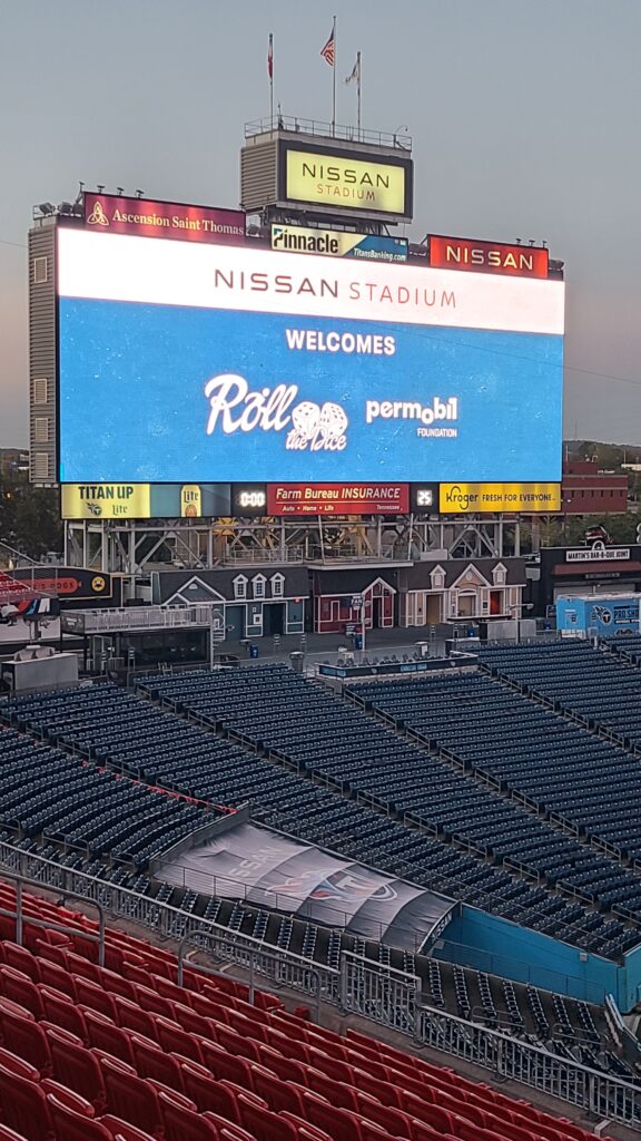 outside image of Nissan Stadium with big welcome to roll the dice CasinoNight by permobil foundation
