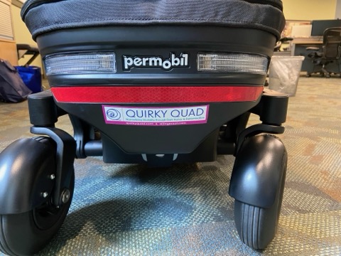 picture of the back of bottom of power wheelchair with quirkyquad logo